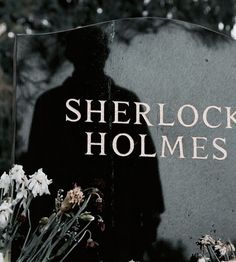 there is a sign that says sherlock homes with flowers in the foreground