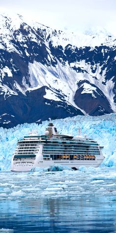 a cruise ship in the water near some icebergs and snow covered mountain peaks