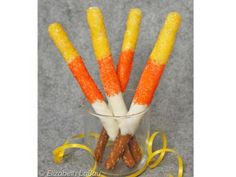 candy canes with orange and white frosting in a glass on a gray surface