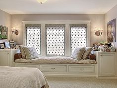 a bedroom with two windows and white furniture