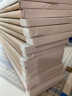 a stack of folded papers sitting on top of a cutting board next to a ruler