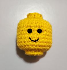 a crocheted yellow object with a smiley face