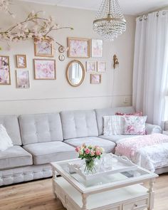 a living room filled with furniture and pictures on the wall above it's coffee table