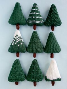 knitted christmas trees are arranged in rows on a blue background with white and green accents