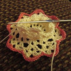 a crocheted flower is being worked on