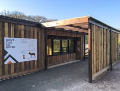 a wooden building with a sign on the side of it that says, dog park