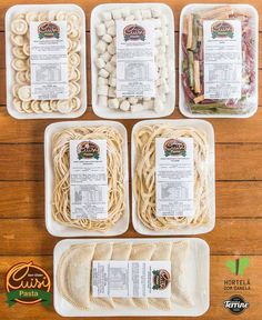 four plastic trays filled with different types of noodles and vegetables on top of a wooden table