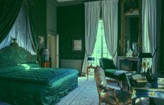 the bedroom is decorated in green and gold colors, with an antique style bed set