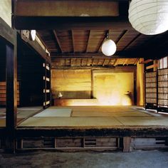 an empty room with tatami mats on the floor and lanterns hanging from the ceiling