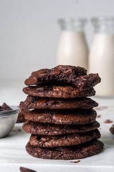 chocolate cookies stacked on top of each other with milk in the backgroung