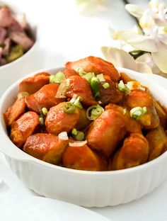 two bowls filled with food sitting on top of a white table next to each other