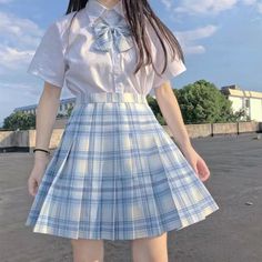 a young woman wearing a blue and white plaid skirt