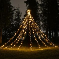 a lighted teepee in the middle of a field at night