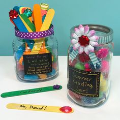 two jars filled with different colored pencils next to each other on top of a table