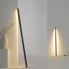 two tall lamps are next to each other in a room with white walls and flooring