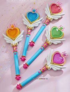 four heart shaped pencils with wings and hearts on them, sitting next to each other