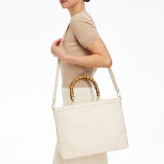 Meet Emily, exquisitely elegant, this handbag is made from gorgeous pebbled leather and designed for work or play with genuine bamboo handles and a spacious, organized interior that fits a 14"laptop and features an unexpected, but classic, striped lining. Add a classic foil monogram to make it yours.    15"w x 5"d x 11.5"h  Please see Product Information for more dimensions.  Pebbled leather, bamboo, striped lining (92% polyester, 8% cotton 8%)  Clean with a dry cloth.  Imported.  Monogramming i Bamboo Handles, Pebbled Leather, Leather Tote, Camel, Foil, Handles, Blush, Laptop, Monogram