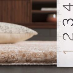 a close up of a bed with a ruler on the floor next to it and a pillow