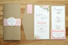 the wedding stationery is laid out on top of brown paper and pink ribbon, along with matching envelopes