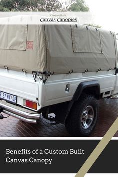 the back end of a white truck with a canvas cover on it's bed