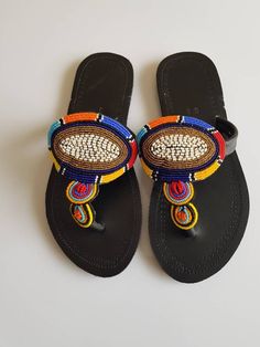 Maasai sandals made with high quality leather and colorful fine beads. **This listing is for 9 pair of sandals. All assorted colors and designs. * The sandals come in different sizes. From size 37 EU to 42 EU.(You can request the sizes you would like). This listing is for resellers or those who want to gift family and friends. Perfect for outdoor summer events , beach wear , festivals , African themed events etc. Buy multiple items and pay shipping for one item Only. Back to my shop; https://www Traditional Multicolor Sandals With Round Toe, Traditional Beaded Toe Post Flip Flops, Traditional Beaded Flip Flops With Round Toe, Traditional Beaded Toe Post Sandals, Traditional T-strap Sandals With Round Toe, Traditional Beaded Sandals With Round Toe, Traditional Multicolor Toe Post Sandals, Multicolor Round Toe Sandals For Festivals, Traditional Black Beaded Sandals