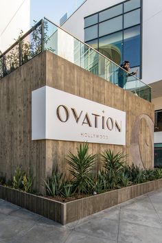 there is a sign that says ovation hollywood on the side of a building with succulents