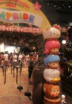 the entrance to an amusement park decorated with hello kitty heads and other characters on it