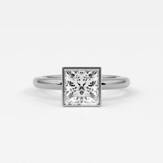 Princess cut diamonds exude modern elegance when set in a bezel setting. This setting surrounds the diamond with a sleek metal rim, securing it firmly while emphasizing its square shape and dazzling facets. The bezel setting not only protects the princess cut diamond from everyday wear but also enhances its brilliance by minimizing distractions and focusing attention on its clean lines and geometric precision. Perfect for those who appreciate a blend of contemporary style and practical design in their jewelry, princess cut diamonds in a bezel setting showcase a sophisticated allure that is both refined and durable. Ring shown is 2 ct diamond. Jewelry Princess, Bezel Set Earrings, Signature Bracelet, Diamond Stacks, Bridal Diamond Jewellery, Princess Cut Diamond, Diamond Education, Bridal Bands, Diamond Charm