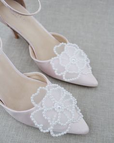 Classic satin pointy toe heels adorned with large white pearl primrose flower applique. Sleek and glamour is a great combination and will definitely be a favorite. DETAILS: HEELS: 3 inches COLORS AVAILABLE: Dusty Pink, Light Blue, Black, Champagne, Ivory, and White UPPER: Synthetic upper and lining MATERIALS: Manmade outsole ORIGIN: Imported STYLE NAME: BELL Elegant Embellished Wedding Shoes For Bridesmaid, Elegant Embellished Bridesmaid Wedding Shoes, Elegant Closed Toe Bridal Accessories For Bridesmaid, Elegant Embellished Heels For Wedding, Glamorous Pearl-embellished Wedding Shoes For Formal Occasions, Elegant Pearl Embellished Heels For Wedding Guest, Elegant Pointed Toe Bridesmaid Wedding Shoes, Elegant Low Heel Bridesmaid Heels, Elegant Almond Toe Heels For Bridesmaid