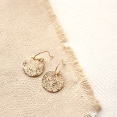 "Sweet little discs of shimmering gold. I have given the metal a \"raw silk\" texture. It is subtle and unique. Discs measure 1/2\". Total length 1\". Handmade shepherd hook earwires. 14k gold fill. About 14k gold fill: 14K gold filled wire is a professional jewelers grade wire. Gold filled wire is not plated. It is a tube of solid 14K gold mechanically bonded to a brass or silver base. There is 100 times more gold in gold filled than in gold plate wire. This layer of gold must be a minimum of 1 Nickel Free Gold Hoop Earrings For Festive Occasions, Gold Nickel-free Hoop Earrings For Festive Occasions, Nickel-free Gold Hoop Earrings For Festive Occasions, Festive Gold Hoop Earrings Nickel Free, Delicate Gold Brass Hoop Earrings, Delicate Gold Hoop Earrings In Brass, Hammered Round Disc Earrings For Gift, Hammered Round Disc Earrings As Gift, Dainty Adjustable Gold Earrings