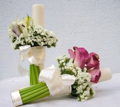 two bouquets of flowers sitting next to each other on top of a white table