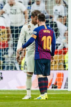 two men standing next to each other on a soccer field