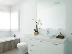 a bathroom with a sink, toilet and bathtub next to a window in it