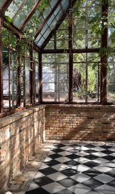 the inside of a building with many windows and plants growing on the outside side of it