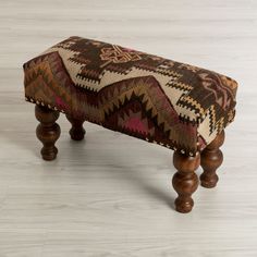 a foot stool made out of wood with a multicolored pattern on the top