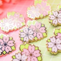 some pink and green flowers are sitting on a table with other things in the background