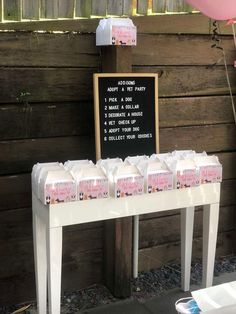 a white table topped with lots of boxes of milk next to a sign that says don't drink