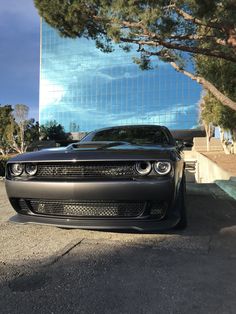 a black car parked in front of a tall building