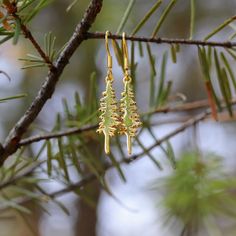 Branch out with these playful Pine Tree Earrings. These gold plated beauties are hypo allergenic and perfect for sensitive ears. Standing at 1", these quirky earrings are the perfect way to add a touch of nature to your jewelry collection. A Montana Scene Original Design. All designs are property of The Montana Scene. All rights reserved. All of The Montana Scene apparel is designed and printed locally in Montana. Come visit our storefront locations! Bigfork * Whitefish * Missoula * Kalispell * Nature-inspired Dangle Hoop Earrings, Nature-inspired Dangle Hoop Earrings As Gift, Nature-inspired Dangle Hoop Earrings For Gift, Nickel-free Nature-inspired Earrings As Gift, Nickel-free Nature-inspired Earrings For Gift, Whimsical Gold Hoop Earrings Gift, Whimsical Gold Hoop Earrings As Gift, Whimsical Gold Hoop Earrings For Gift, Nature-inspired Nickel-free Gold Earrings