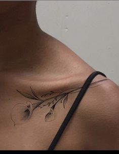 a woman's chest with an apple and flower tattoo on her left side shoulder