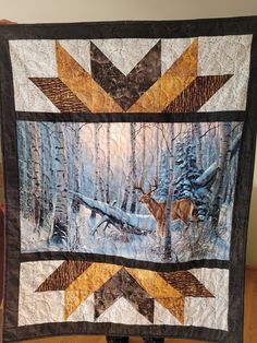 a quilted wall hanging with an image of a deer in the woods