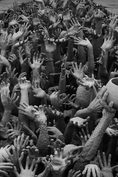 black and white photograph of many hands reaching out to each other