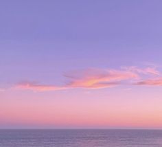 the sky is pink and purple over the ocean