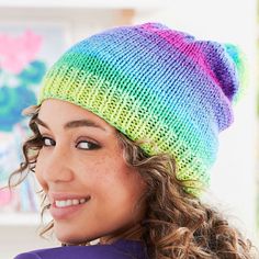 a young woman wearing a multicolored knitted hat