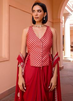 Elevate your wardrobe with this exquisite Red Embroidered Skirt Set, crafted from luxurious chanderi jacquard. The vibrant red blouse, adorned with intricate embroidery, exudes sophistication and style, making it perfect for festive occasions and special gatherings. Paired with a flowing skirt that drapes elegantly, this ensemble creates a flattering silhouette, blending traditional craftsmanship with contemporary design for a look that is both timeless and captivating. Style it with a layered c Red Cotton Silk Sharara With Cutdana, Red Cotton Silk Sharara With Cutdana Details, Red Cotton Silk Sharara With Traditional Drape, Festive Red Cotton Silk Traditional Wear, Red Traditional Cotton Silk Sharara, Traditional Red Cotton Silk Sharara, Red Cotton Silk Traditional Wear With Traditional Drape, Red Semi-stitched Cotton Silk Sharara, Red Cotton Silk Sharara For Diwali