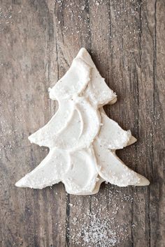 a white frosted christmas tree on top of a wooden table