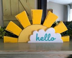 a yellow and white hello sign sitting on top of a table