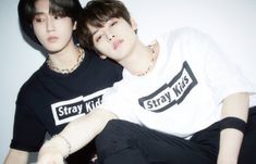 two young men sitting next to each other wearing black and white t - shirts with the words stay wild on them