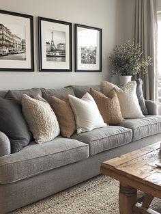 a living room with couches and pictures on the wall above them, along with a coffee table