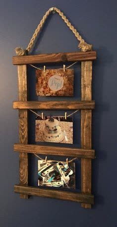 a wooden frame with pictures hanging from it's sides and rope on the wall